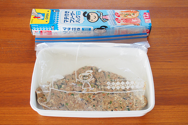 イワシ缶や豆腐、にんじん、芽ひじき、青ねぎなどを入れて、バッグを揉むようにしてよく混ぜます